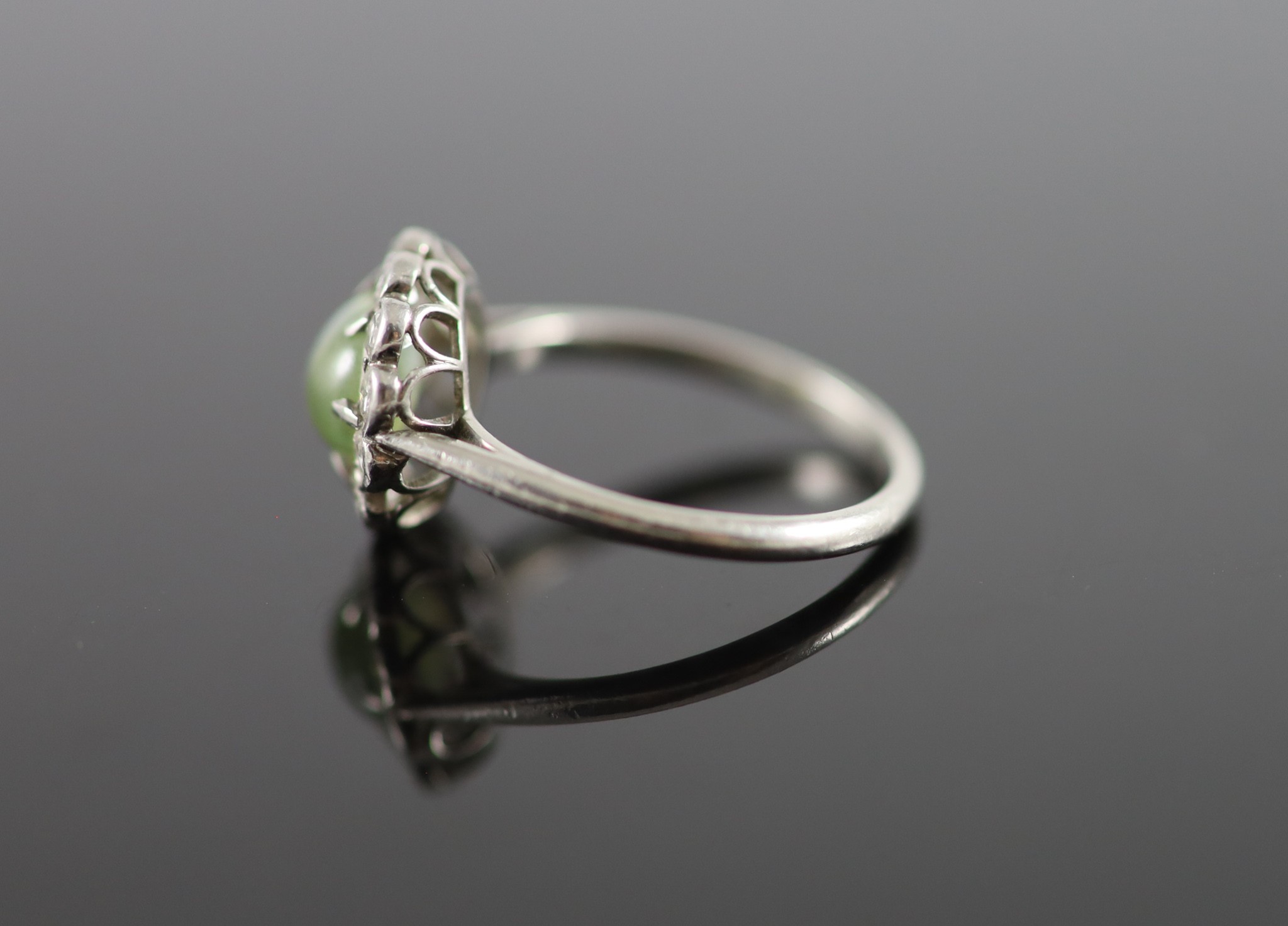 A 1920's/1930's platinum, cats eye chrysoberyl and diamond set oval cluster ring